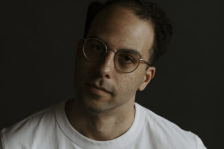 A photo of poet D.M. Bradford, a Black man with freckles and wire-rimmed glasses.