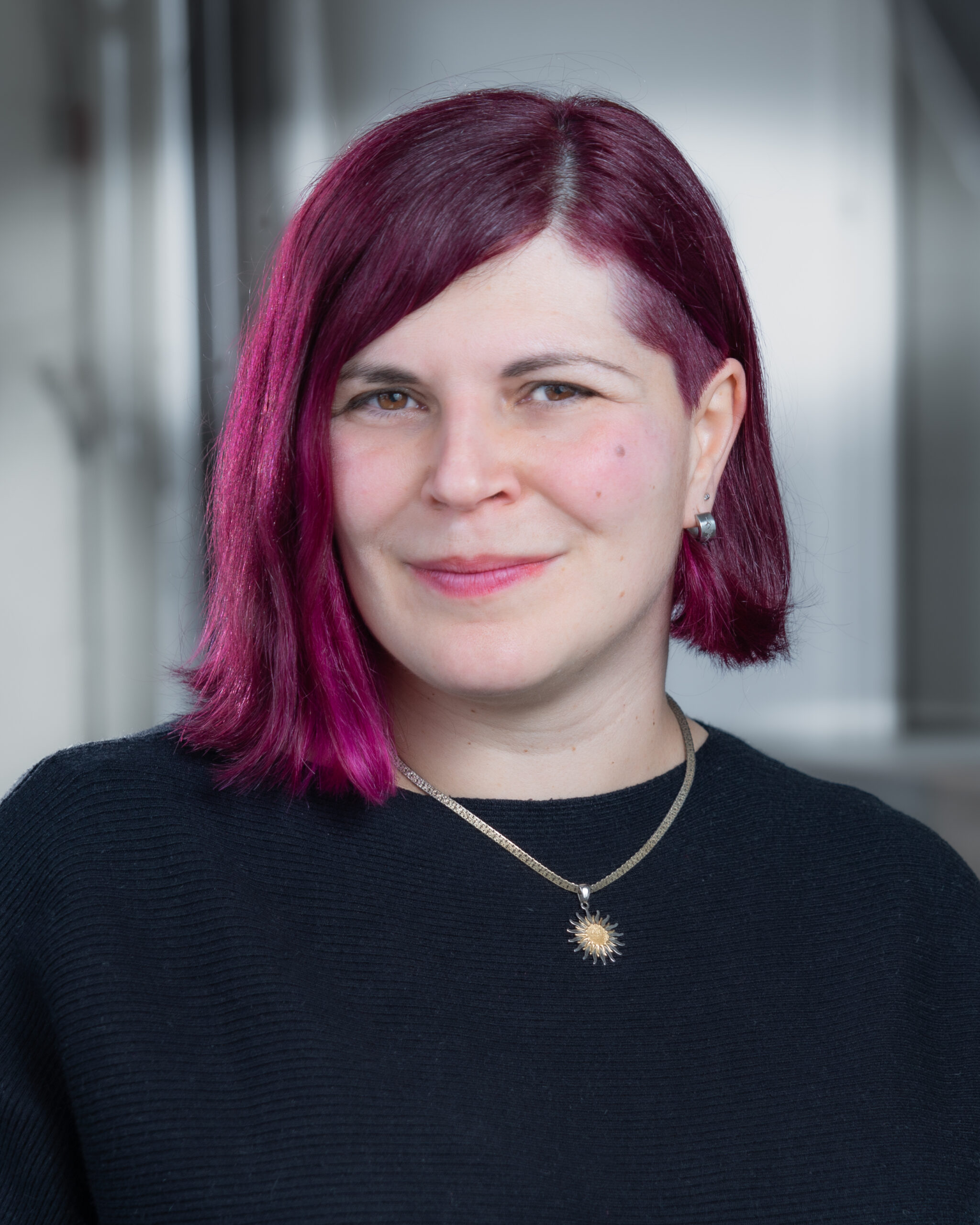 An image of writer Paola Ferrante, a light skin-toned woman with chin-length purple hair.