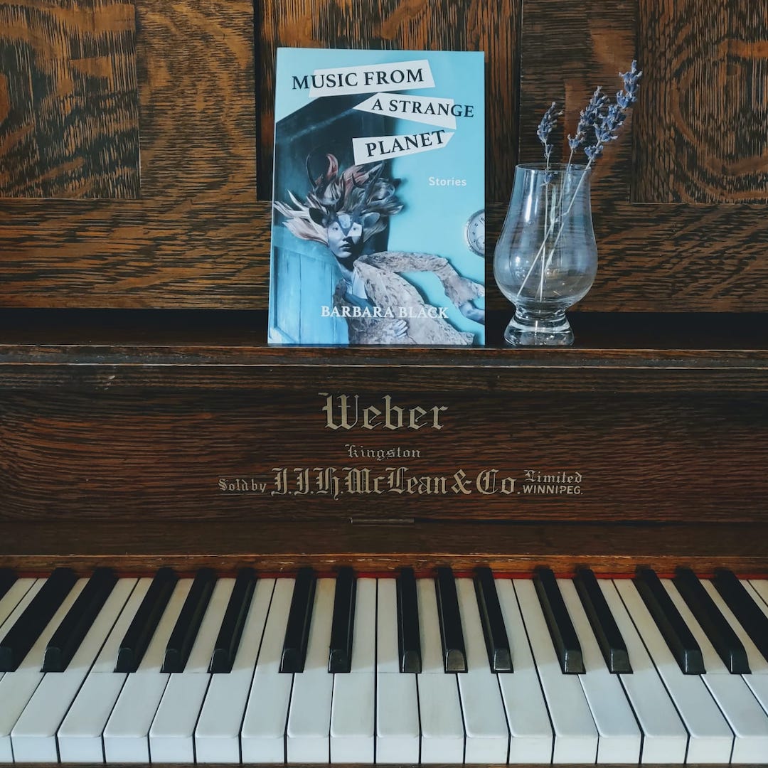 A copy of Music from a Strange Planet by Barbara Black sits on the music ledge of a Weber piano.