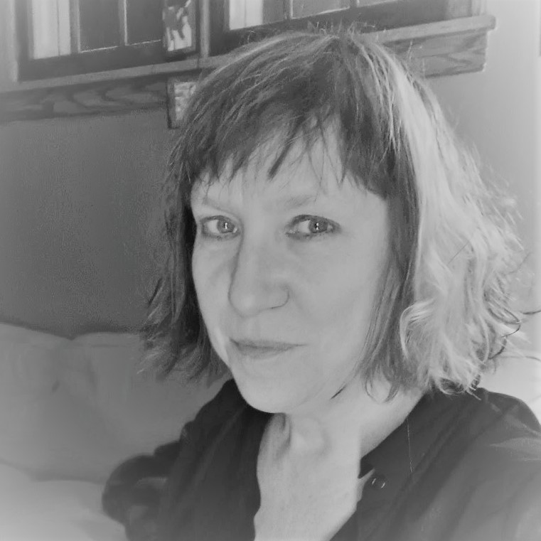 A black and white photo of poet Sue Sorensen. She is a light-skin toned woman with a chin-length bob.