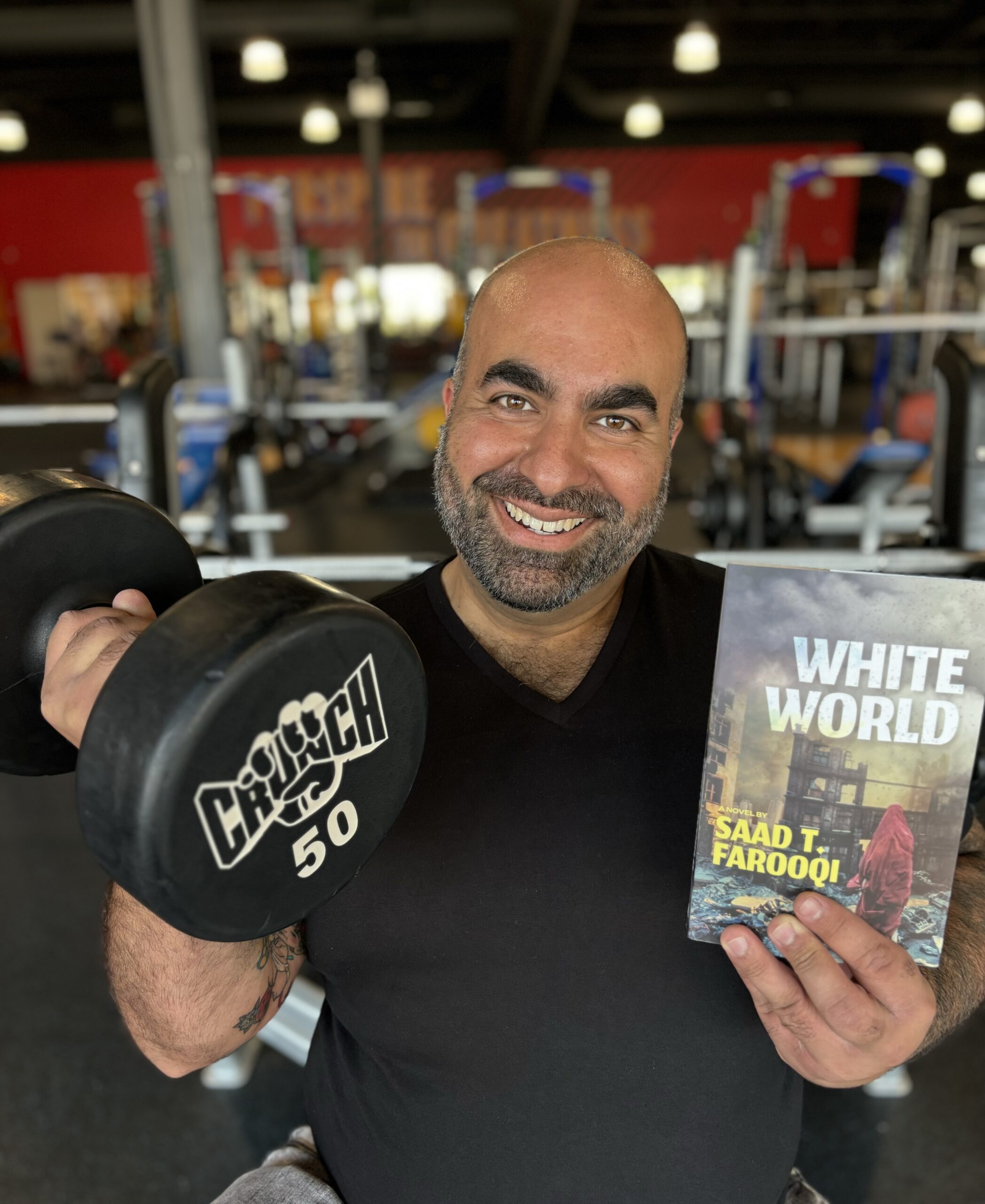 Author Saad T. Farooqi holding a copy of his book White World in one hand, and a 50-pound dumbell in the other