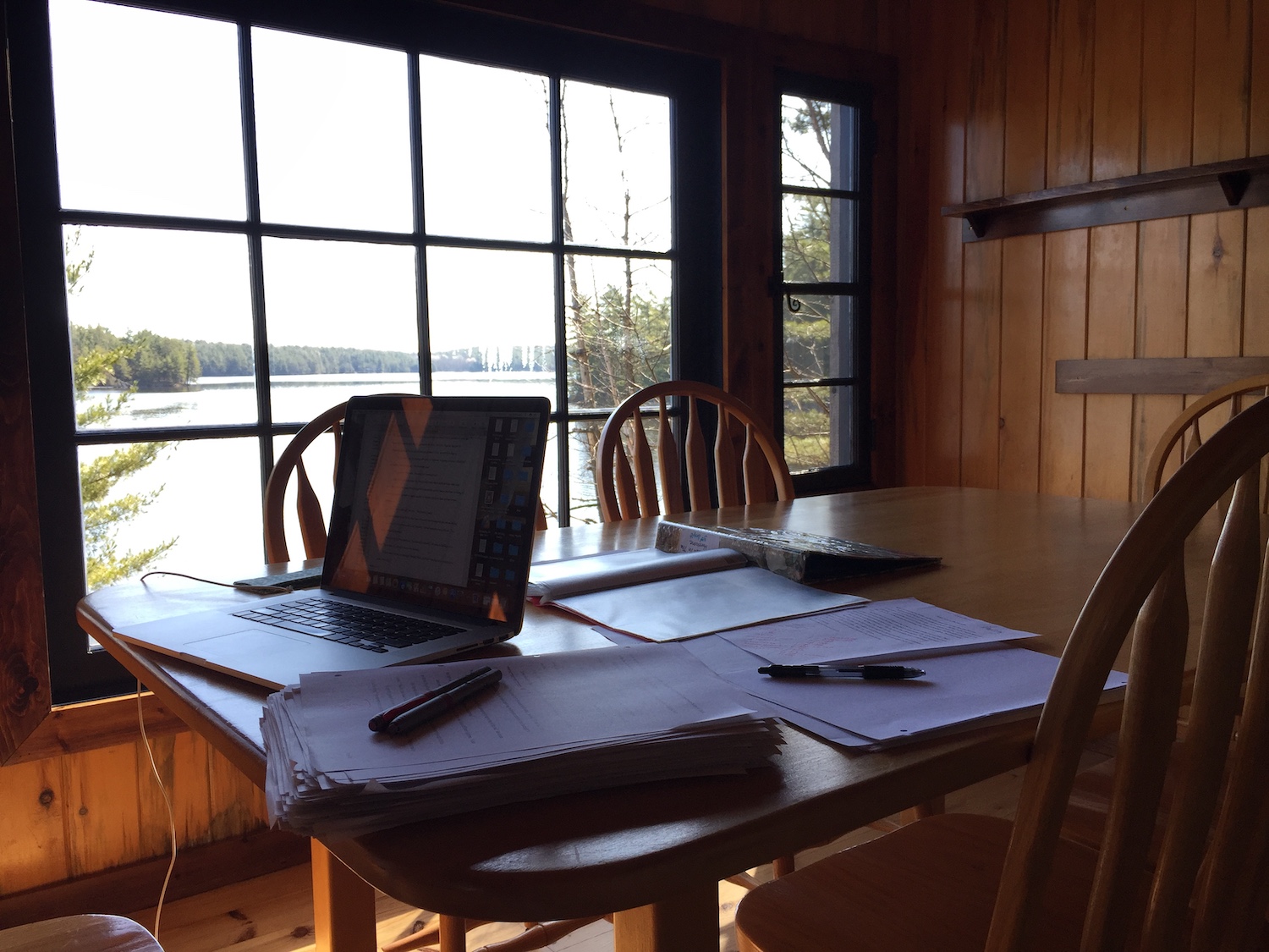 A photo of Louise Ells' desk overlooking a huge window and a lake.