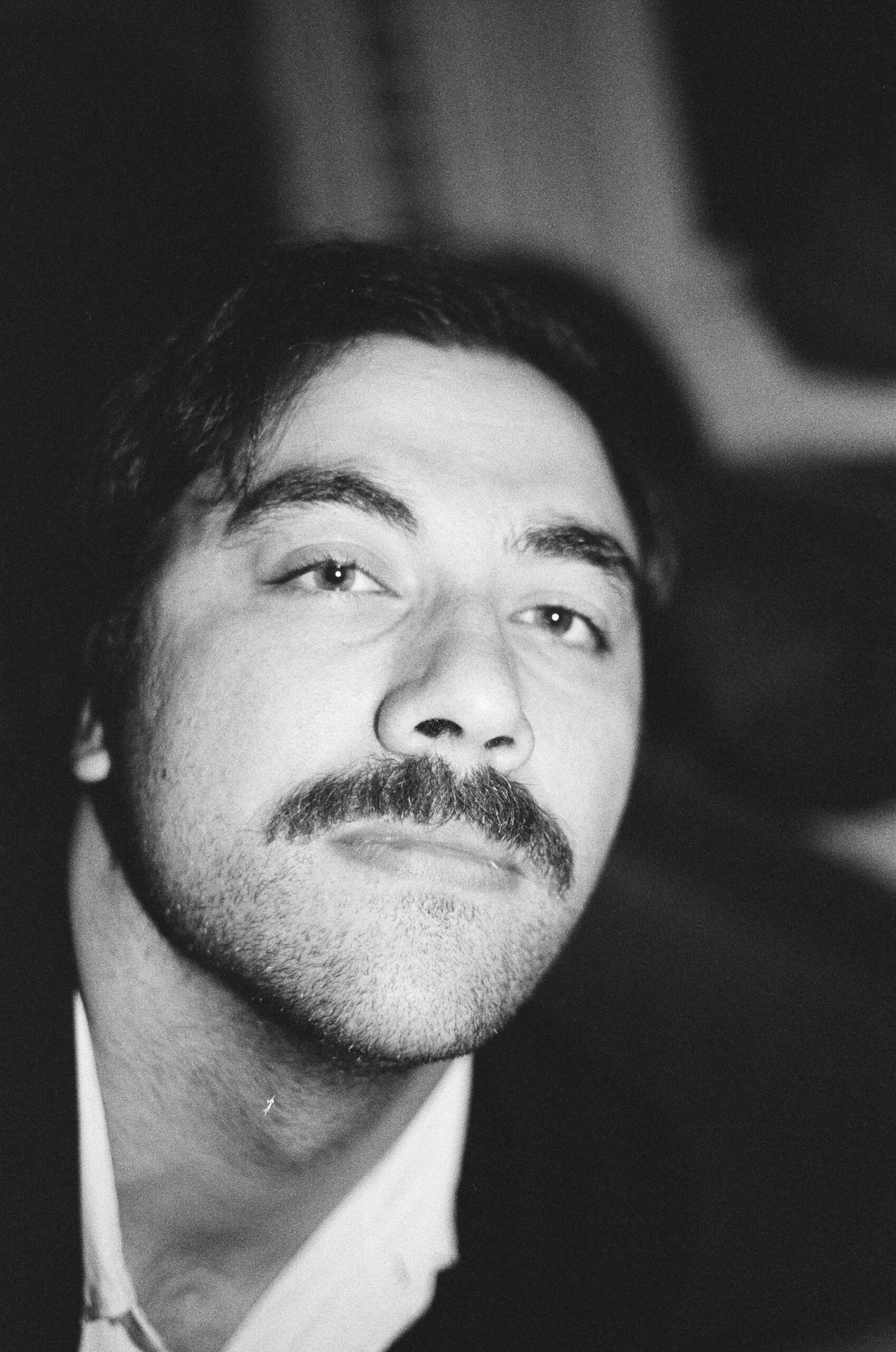 A black-and-white photo of Adam Haiun. He is a light-skin-toned man with dark hair and a moustache. 