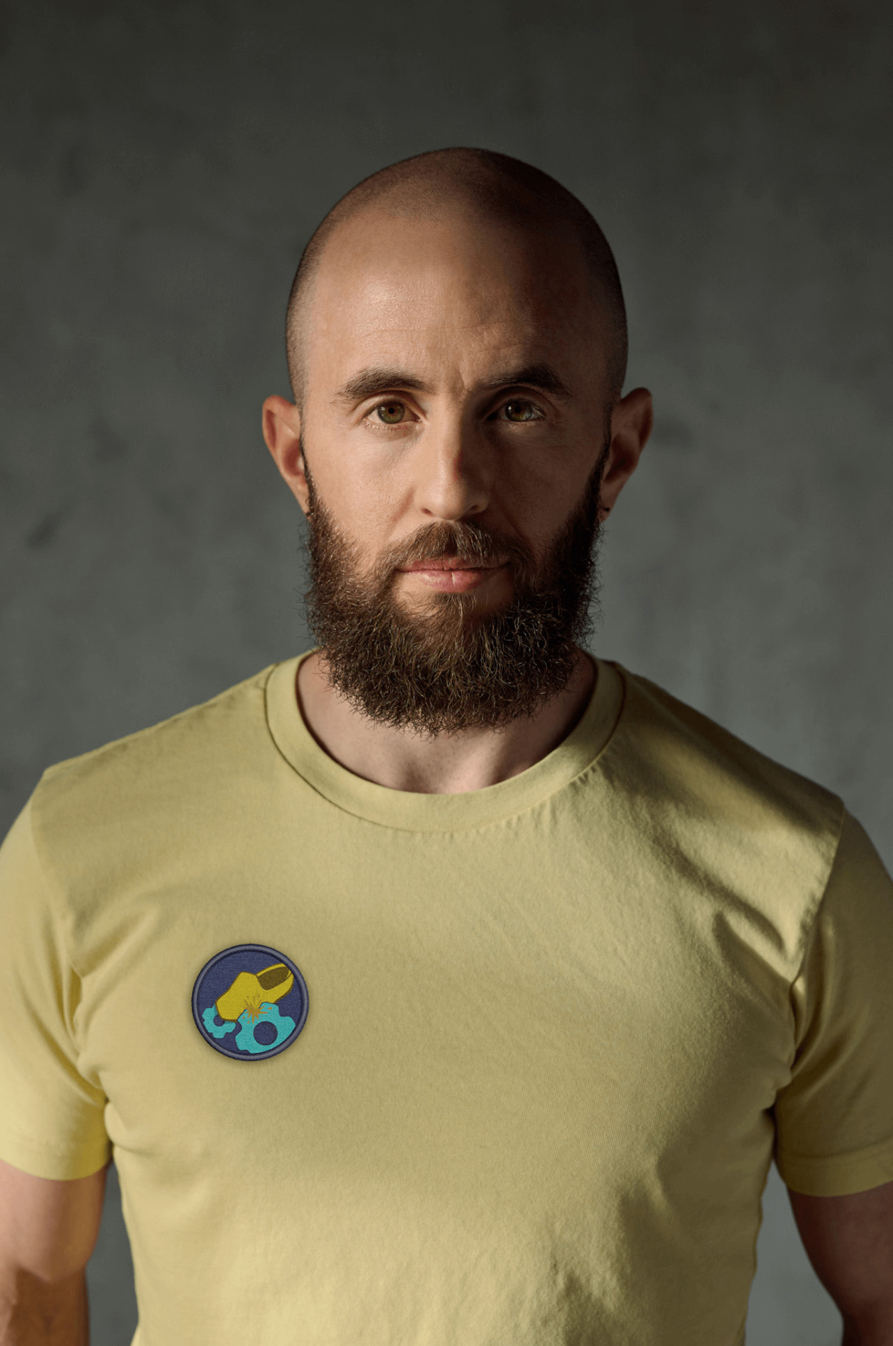 A photo of Ben Zalkind. He is a light-skin-toned man with a short brown beard. He is wearing a yellow t-shirt with a small graphic. 